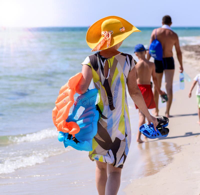 De familie met kleine kinderen met dingen gaat langs de Zwarte Zee stock foto's De familie met kleine kinderen met dingen gaat langs de Zwarte Zee stock foto's