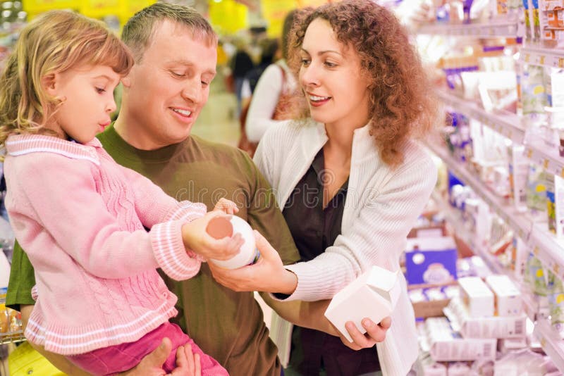 De familie met meisje koopt melk in supermarkt royalty-vrije stock foto's De familie met meisje koopt melk in supermarkt royalty-vrije stock foto's