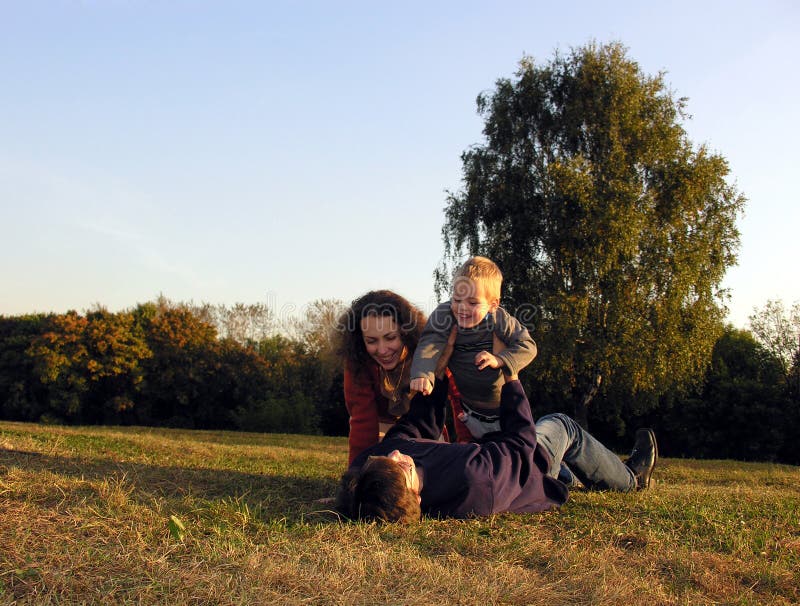 De familie speelt de herfst op zonsondergang op open plek royalty-vrije stock afbeeldingen De familie speelt de herfst op zonsondergang op open plek royalty-vrije stock afbeeldingen