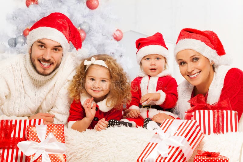 De familie van vier met stelt en Kerstboom voor royalty-vrije stock afbeeldingen De familie van vier met stelt en Kerstboom voor royalty-vrije stock afbeeldingen