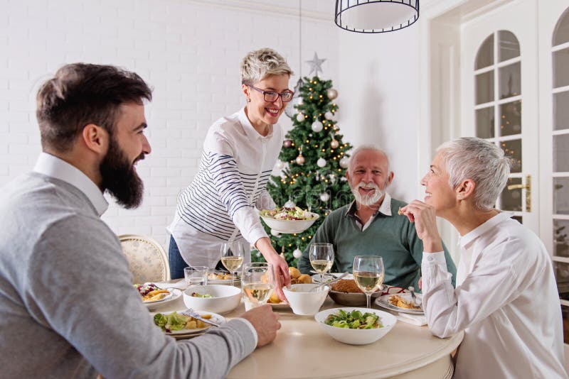 De familie verzamelde zich over Kerstmisvakantie, vierend, hebbend lunch royalty-vrije stock foto De familie verzamelde zich over Kerstmisvakantie, vierend, hebbend lunch royalty-vrije stock foto