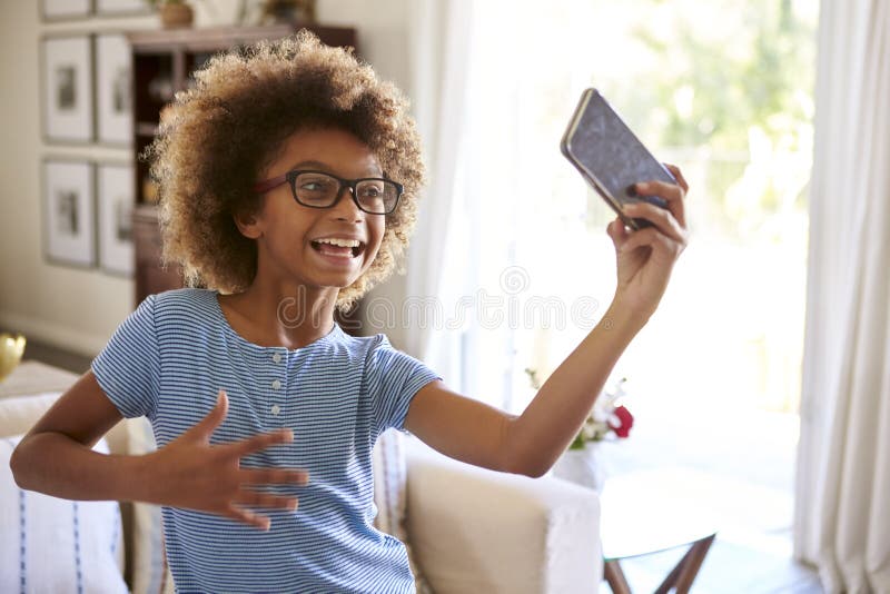 De film van het pre-tienermeisje zelf het zingen gebruiken sociale media app op haar smartphone, sluit omhoog royalty-vrije stock afbeelding De film van het pre-tienermeisje zelf het zingen gebruiken sociale media app op haar smartphone, sluit omhoog royalty-vrije stock afbeelding