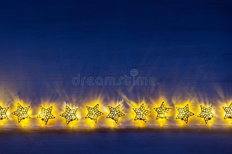 De fonkelende brandwond van lichtensterren op donkerblauwe houten raad royalty-vrije stock fotografie De fonkelende brandwond van lichtensterren op donkerblauwe houten raad royalty-vrije stock fotografie