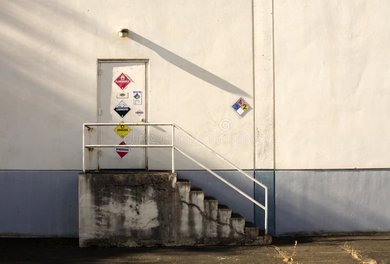 Photo of a door leading into a factory with interesting danger signs. Photo of a door leading into a factory with interesting danger signs.