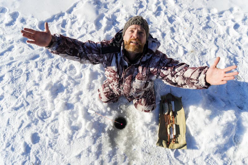 De gebaarde Europese droevige mens bidt terwijl hij die bij de de winter visserij ontbreekt krijgen stock fotografie De gebaarde Europese droevige mens bidt terwijl hij die bij de de winter visserij ontbreekt krijgen stock fotografie