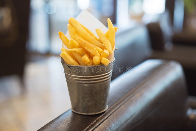 De gebraden gouden Frieten wordt ingepakt in een kleine metaalemmer royalty-vrije stock afbeeldingen De gebraden gouden Frieten wordt ingepakt in een kleine metaalemmer royalty-vrije stock afbeeldingen