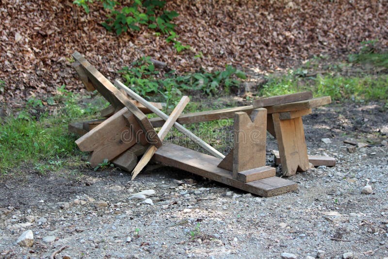 De gebroken eigengemaakte houten banken gingen op grintweg weg in lokaal bos na groot onweer en vloed royalty-vrije stock fotografie De gebroken eigengemaakte houten banken gingen op grintweg weg in lokaal bos na groot onweer en vloed royalty-vrije stock fotografie