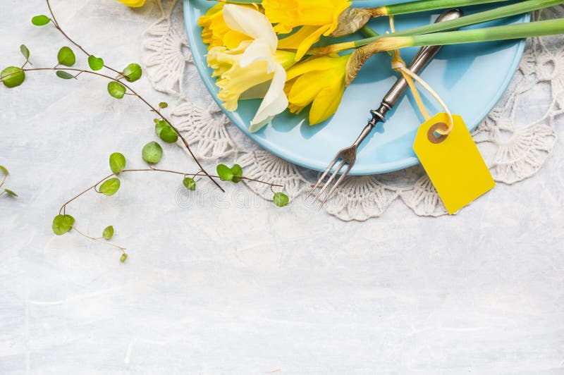 De gele gele narcissen op blauwe plaat met vork en lijst ondertekenen, de lentedecoratie royalty-vrije stock foto De gele gele narcissen op blauwe plaat met vork en lijst ondertekenen, de lentedecoratie royalty-vrije stock foto