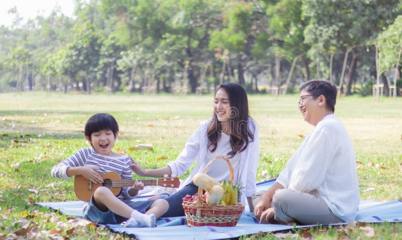 De gelukkige Aziatische familie heeft vrije tijd in het park tijdens het weekend of vakantie Moeder en gezonde grootmoeder geniet stock afbeeldingen De gelukkige Aziatische familie heeft vrije tijd in het park tijdens het weekend of vakantie Moeder en gezonde grootmoeder geniet stock afbeeldingen