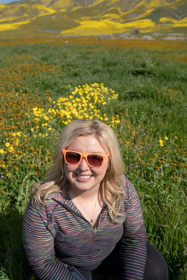 De gelukkige blondevrouw stelt met wildflowers in het Carrizo Duidelijke Nationale Monument royalty-vrije stock fotografie De gelukkige blondevrouw stelt met wildflowers in het Carrizo Duidelijke Nationale Monument royalty-vrije stock fotografie