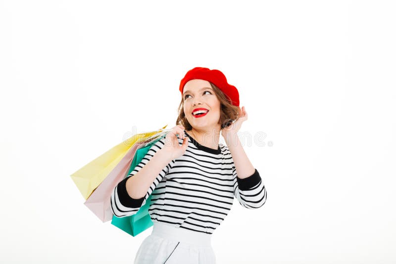 De gelukkige gembervrouw met pakketten verbetert kapsel en weg het kijken stock foto's De gelukkige gembervrouw met pakketten verbetert kapsel en weg het kijken stock foto's