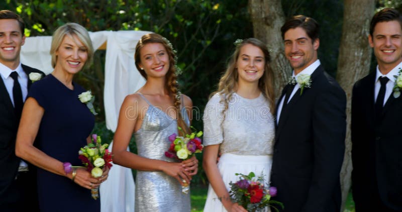 De gelukkige jonge bruid en de bruidegom stellen met familie en vrienden 4K 4k