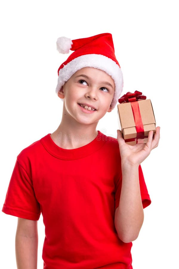 De gelukkige jongen, santahoed op zijn hoofd, ontving de kleine giftdoos in de hand Concept: Kerstmis of Gelukkige Nieuwjaarvakan royalty-vrije stock foto De gelukkige jongen, santahoed op zijn hoofd, ontving de kleine giftdoos in de hand Concept: Kerstmis of Gelukkige Nieuwjaarvakan royalty-vrije stock foto