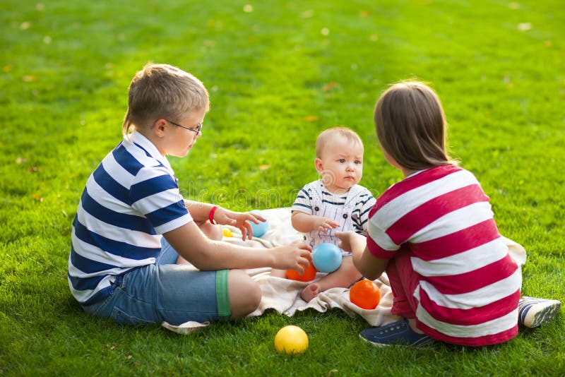 De gelukkige kinderen op groen gras in de zomer parkeren Gezonde levensstijlen stock foto's De gelukkige kinderen op groen gras in de zomer parkeren Gezonde levensstijlen stock foto's