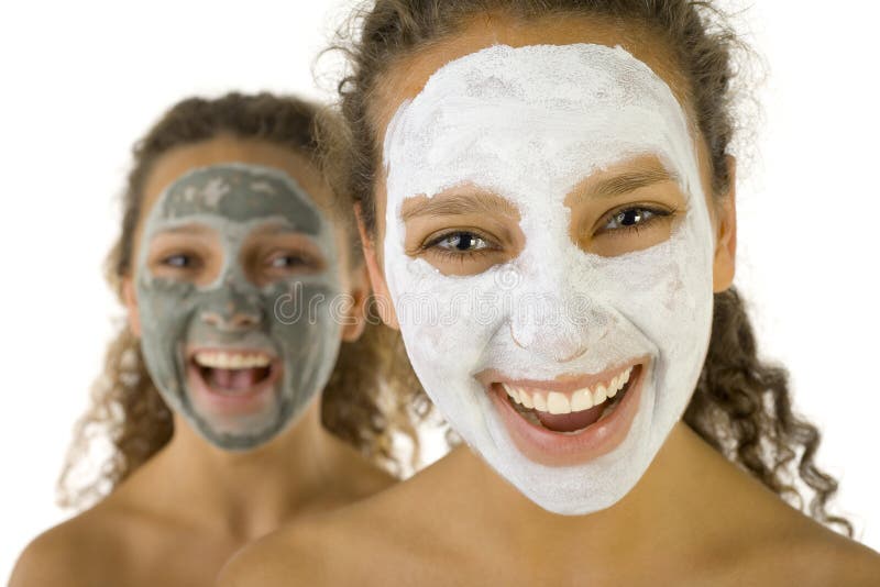 Happy young women with masks anti-aging. Focus on first person. They're on white background. Happy young women with masks anti-aging. Focus on first person. They're on white background.