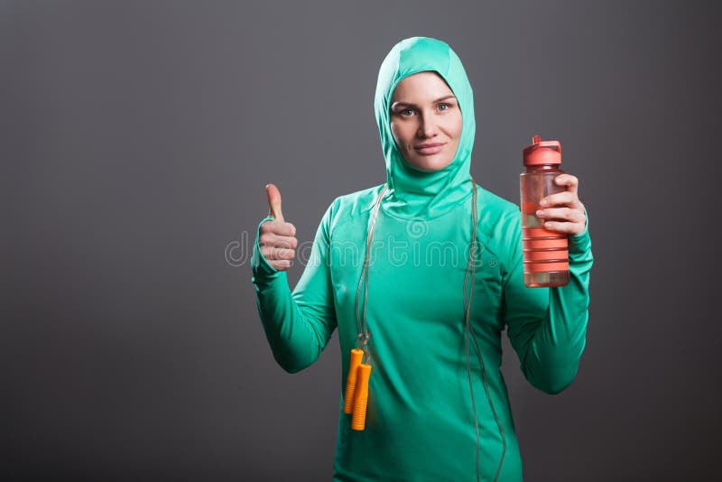 De gelukkige moslimvrouw van de trotsatleet in groene hijab of Islamitische sport royalty-vrije stock foto De gelukkige moslimvrouw van de trotsatleet in groene hijab of Islamitische sport royalty-vrije stock foto