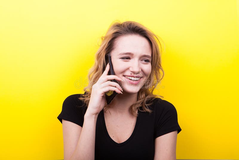 De gelukkige vrouw houdt een smartphone in haar handen stock afbeelding De gelukkige vrouw houdt een smartphone in haar handen stock afbeelding