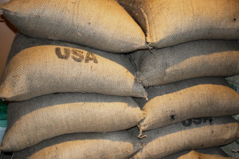 Stacked full bags of coffee - closeup with USA stamped on some of them. Stacked full bags of coffee - closeup with USA stamped on some of them