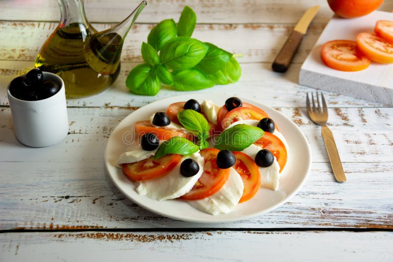 De gezonde de zomersalade maakte met organische Spaanse die tomaten en laag - caloriemozarella met vers basilicum wordt gediend royalty-vrije stock afbeeldingen De gezonde de zomersalade maakte met organische Spaanse die tomaten en laag - caloriemozarella met vers basilicum wordt gediend royalty-vrije stock afbeeldingen
