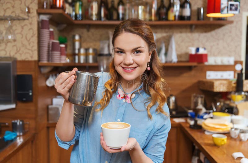 De gietende room van de Baristavrouw aan kop bij koffiewinkel royalty-vrije stock foto's De gietende room van de Baristavrouw aan kop bij koffiewinkel royalty-vrije stock foto's