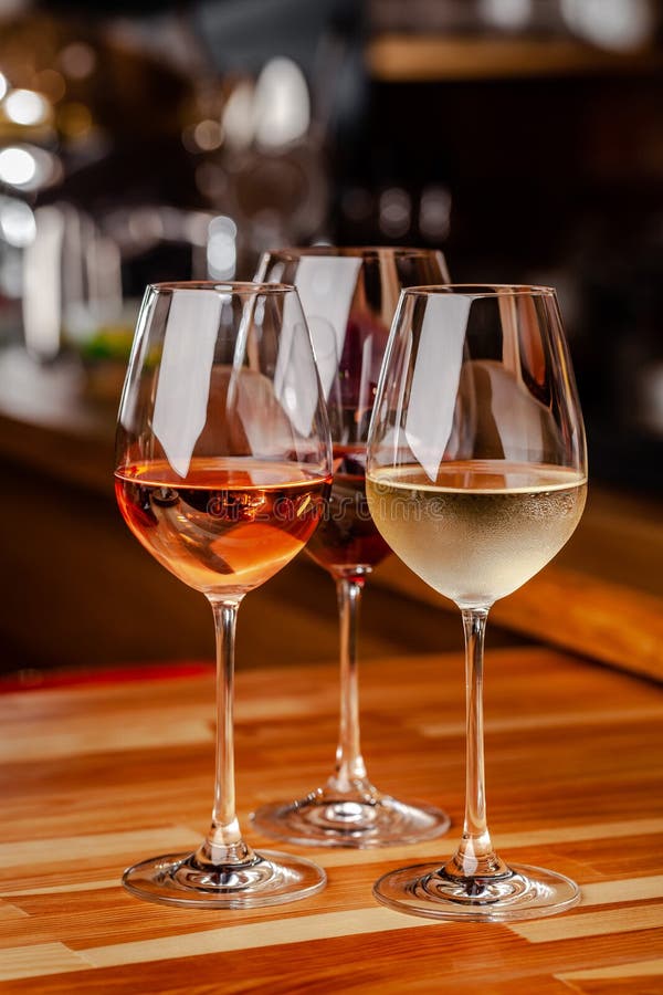 De glazen van wit, namen toe en de rode wijn is op de lijst, een fles en kurkt is nabijgelegen De glazen zijn op de lijst in de b stock fotografie De glazen van wit, namen toe en de rode wijn is op de lijst, een fles en kurkt is nabijgelegen De glazen zijn op de lijst in de b stock fotografie