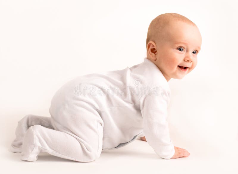 De glimlachende baby kruipt stock foto's De glimlachende baby kruipt stock foto's