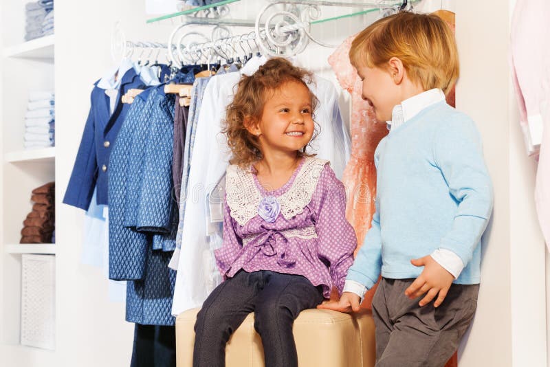 De glimlachende leuke jongen bekijkt meisje terwijl het winkelen stock afbeeldingen De glimlachende leuke jongen bekijkt meisje terwijl het winkelen stock afbeeldingen