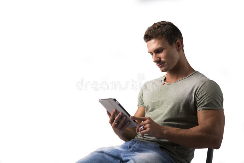De glimlachende lezer van de jonge mensenholding ebook, zitting stock afbeelding De glimlachende lezer van de jonge mensenholding ebook, zitting stock afbeelding