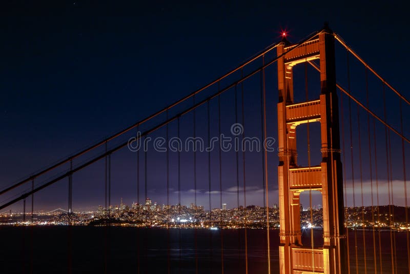 De gloeiende stad van San Francisco door Golden gate bridge stock afbeelding De gloeiende stad van San Francisco door Golden gate bridge stock afbeelding