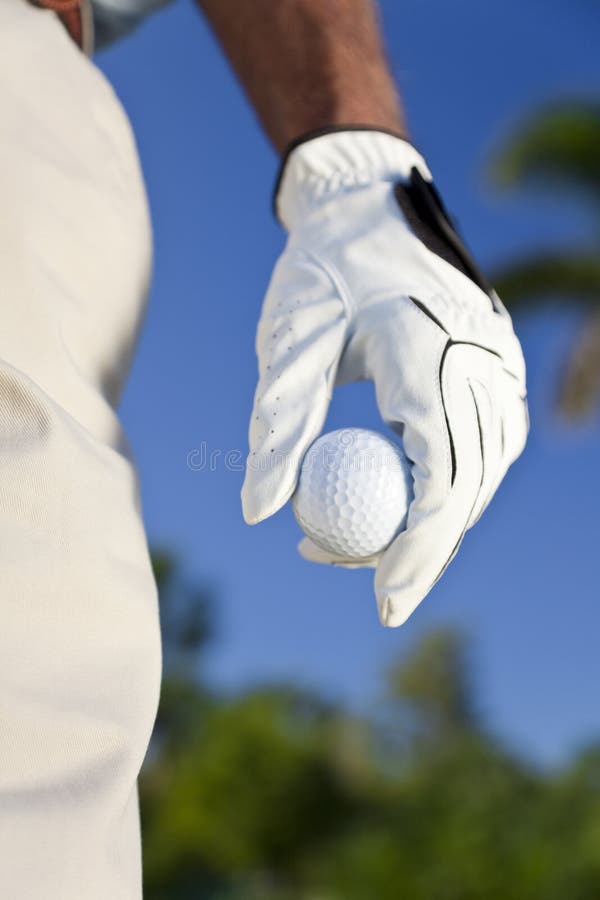 Close up on male golfer's gloved hand holding a golf ball. Close up on male golfer's gloved hand holding a golf ball