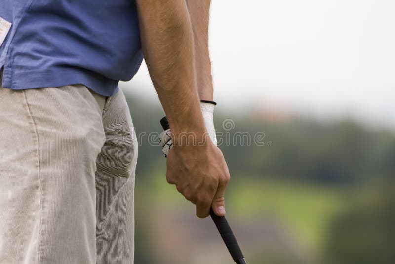 A male golfer is preparing for his swing. Focus on his grip. Outdoor shot. A male golfer is preparing for his swing. Focus on his grip. Outdoor shot.