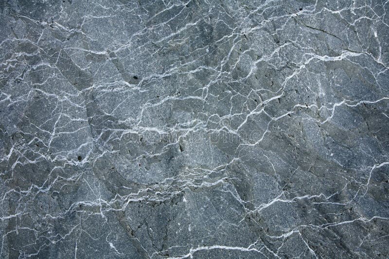De grijze achtergrond van de de textuuroppervlakte van de granietsteen.