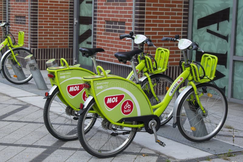 De groene rentable fietsen van MOL Bubi naast Westend-Stadscentrum, in de straat van VÃ ¡ ci stock afbeeldingen De groene rentable fietsen van MOL Bubi naast Westend-Stadscentrum, in de straat van VÃ ¡ ci stock afbeeldingen