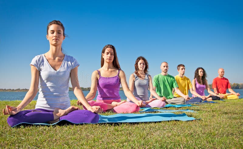De groep jonge mensen heeft meditatie op yogaklasse.