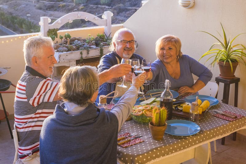 De groep mooie hogere volwassene heeft pret en geniet van een diner outsood op het terras etend samen met glimlachen en pret leis royalty-vrije stock foto De groep mooie hogere volwassene heeft pret en geniet van een diner outsood op het terras etend samen met glimlachen en pret leis royalty-vrije stock foto