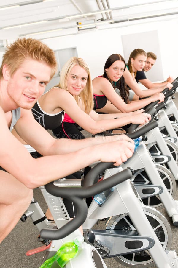 De groep van de geschiktheid mensen op gymnastiekfiets stock foto's De groep van de geschiktheid mensen op gymnastiekfiets stock foto's