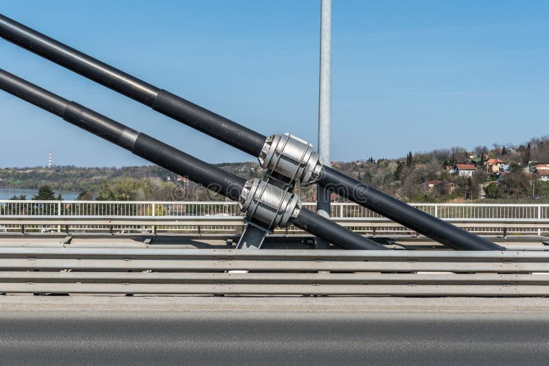 De grote en sterke de kabelverbindingen die van de staalveiligheid de concrete brugbouw houden en lossen trillingen en steunwind stock fotografie De grote en sterke de kabelverbindingen die van de staalveiligheid de concrete brugbouw houden en lossen trillingen en steunwind stock fotografie