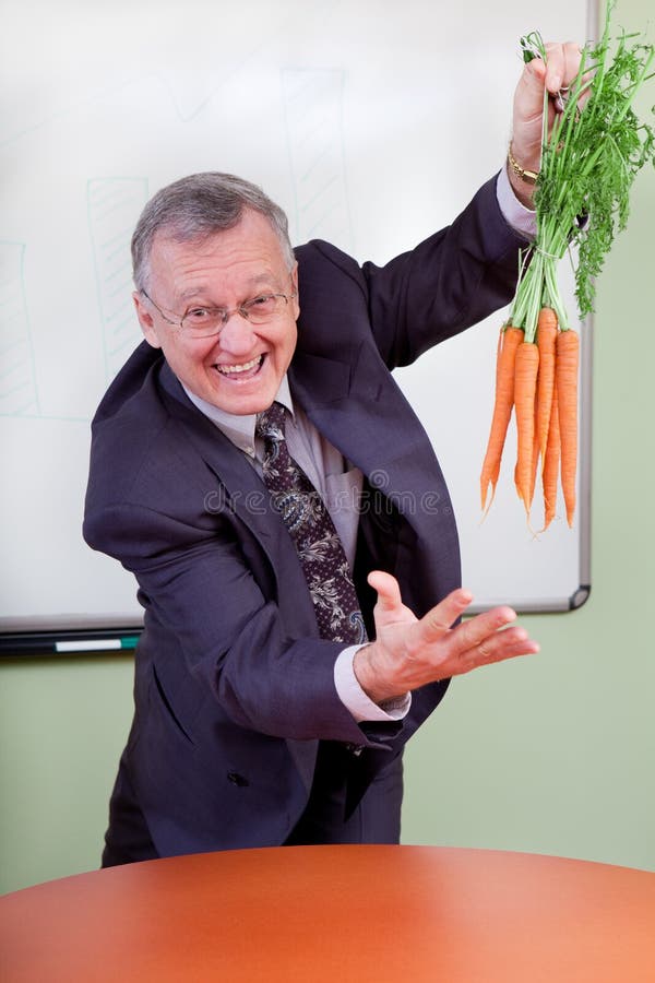 The great motivator dangling carrots in a meeting. The great motivator dangling carrots in a meeting