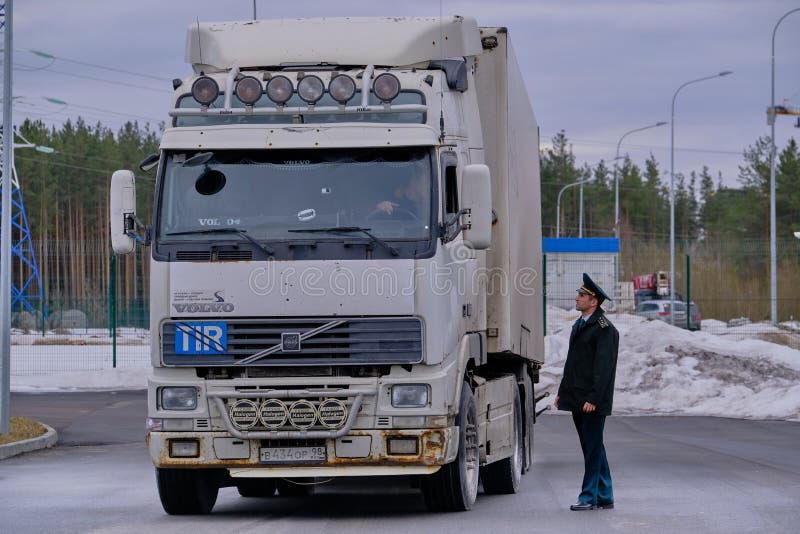 De grote wagen bij de douane post de commies benaderde de vrachtwagenchauffeur om de documenten te controleren stock fotografie De grote wagen bij de douane post de commies benaderde de vrachtwagenchauffeur om de documenten te controleren stock fotografie