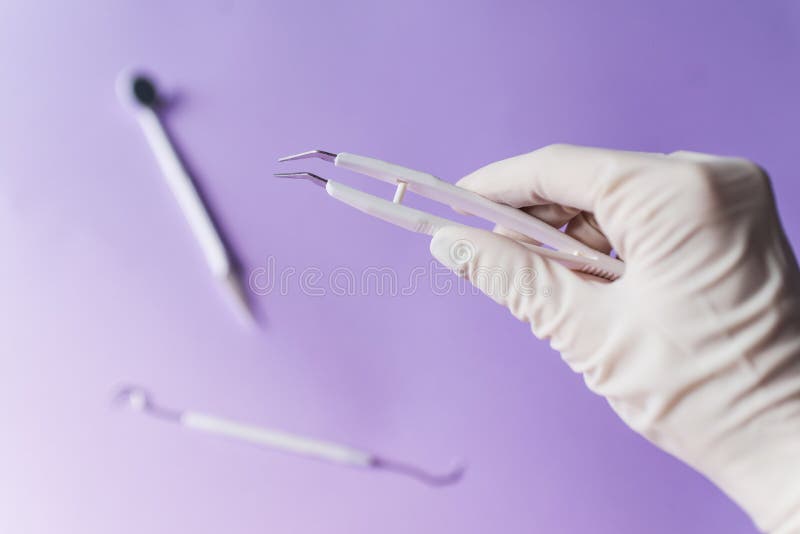 De hand en dentall de instrumenten van de tandarts op kleurrijke achtergrond stock foto De hand en dentall de instrumenten van de tandarts op kleurrijke achtergrond stock foto
