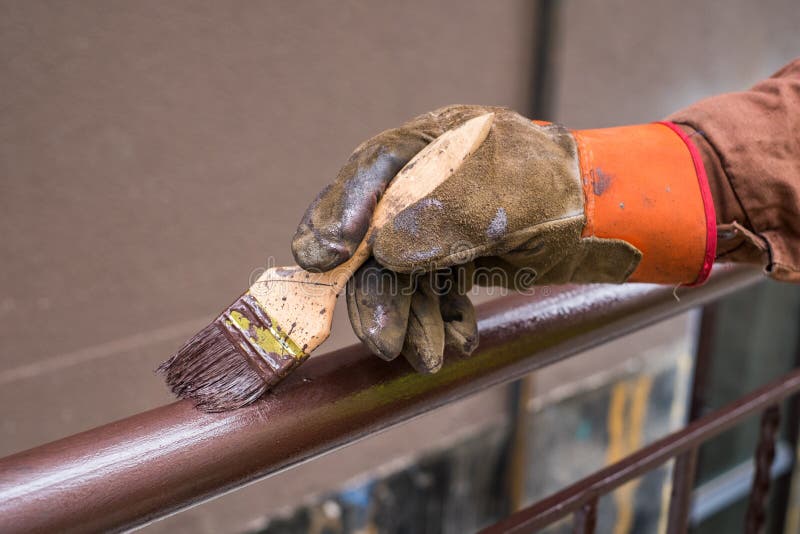 De hand van de contractant met borstel die het schilderen bouw van het metaaltraliewerk royalty-vrije stock afbeeldingen De hand van de contractant met borstel die het schilderen bouw van het metaaltraliewerk royalty-vrije stock afbeeldingen