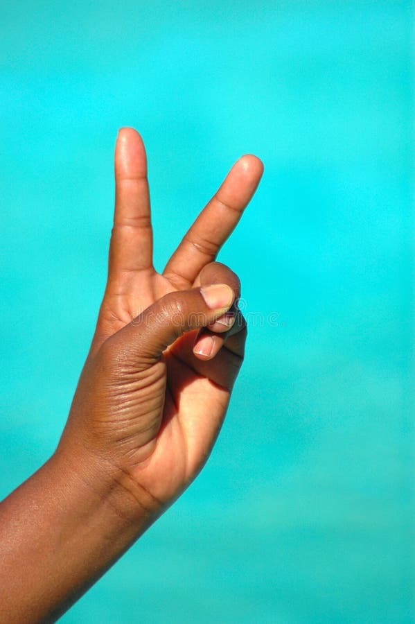The black hand of an African American woman showing the symbolic victory sign after success where she was the winner. The black hand of an African American woman showing the symbolic victory sign after success where she was the winner
