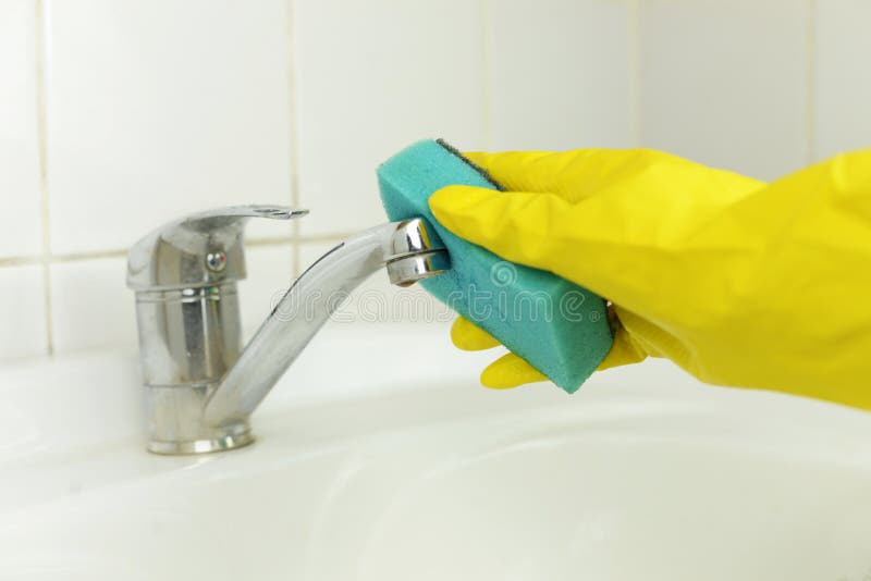 De hand van een mens die het schoonmaken doen veegt een tapkraan met water af royalty-vrije stock foto De hand van een mens die het schoonmaken doen veegt een tapkraan met water af royalty-vrije stock foto