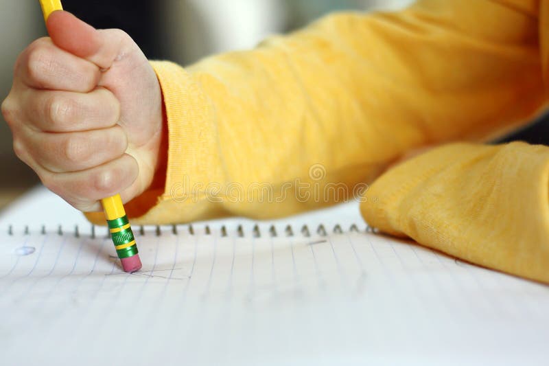 De Hand van het kind het Wissen met Potlood op Notitieboekjedocument stock afbeeldingen De Hand van het kind het Wissen met Potlood op Notitieboekjedocument stock afbeeldingen