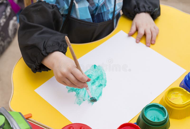 De hand van kinderen met een borstel voor tekening, het kind trekt met verven en borstel op papier stock foto's De hand van kinderen met een borstel voor tekening, het kind trekt met verven en borstel op papier stock foto's