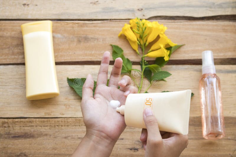 De hand van de roomzonnescherm spf50 van de meisjeshelling beschermt voor huidgezicht stock afbeelding De hand van de roomzonnescherm spf50 van de meisjeshelling beschermt voor huidgezicht stock afbeelding