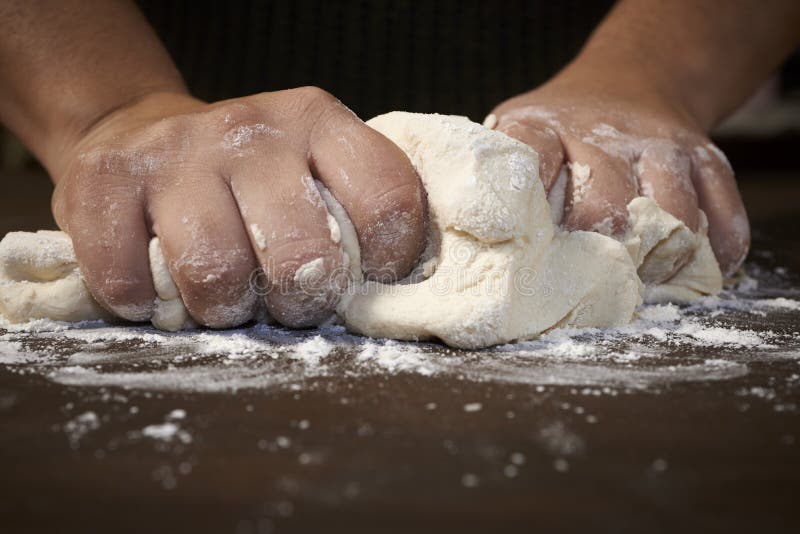 De handen die van de vrouw deeg kneden stock afbeeldingen De handen die van de vrouw deeg kneden stock afbeeldingen