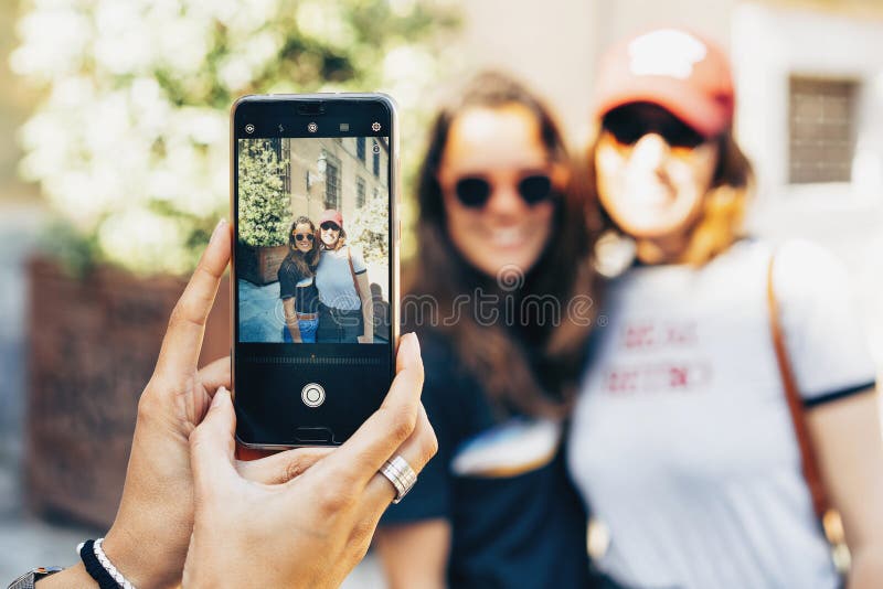 De handen die van het meisje foto met een smartphone van een gelukkig vrouwen lesbisch paar nemen in Madrid Zelfde geslachtsverho stock fotografie De handen die van het meisje foto met een smartphone van een gelukkig vrouwen lesbisch paar nemen in Madrid Zelfde geslachtsverho stock fotografie