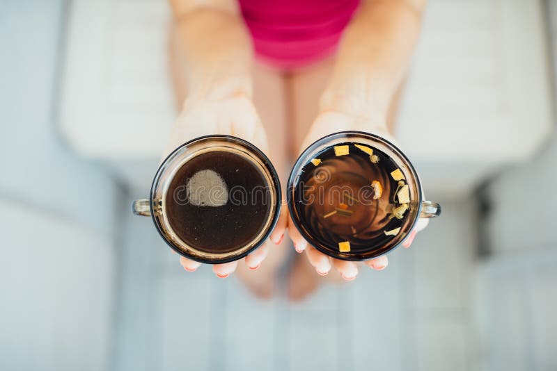De handen die van vrouwen thee en koffie houden royalty-vrije stock fotografie De handen die van vrouwen thee en koffie houden royalty-vrije stock fotografie