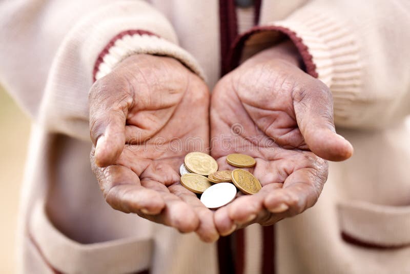 A begger holding out his hands filled with coins. A begger holding out his hands filled with coins.